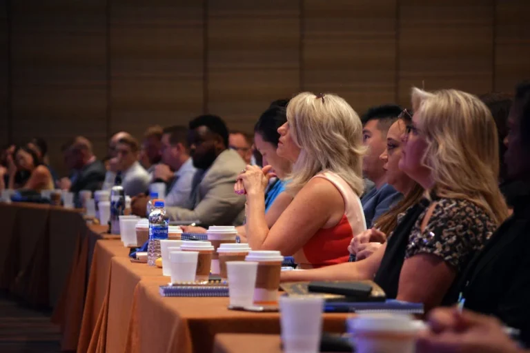 Audience of diverse professionals attentively listening during a conference session.